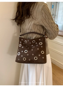 Sophisticated retro dark brown suede tote bag with stylish silver metal eyelets on model