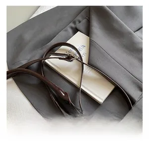 Detail showing the adjustable brown leather strap and silver buckle of the suede tote bag