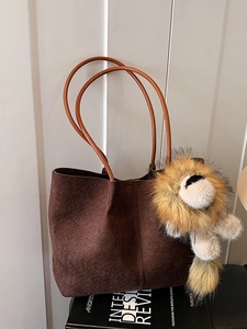 Dark brown suede tote bag with woven texture and a cute lion plush pendant detail