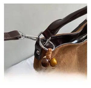 Close-up of premium silver metal hooks and texture detail on brown suede tote bag