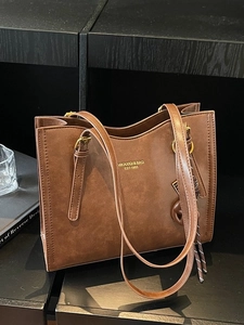 Large vintage brown faux leather tote bag with gold branding and adjustable shoulder strap