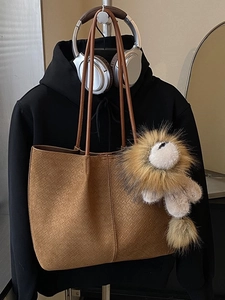 Large brown suede tote bag with woven texture and lion plush charm for autumn fashion
