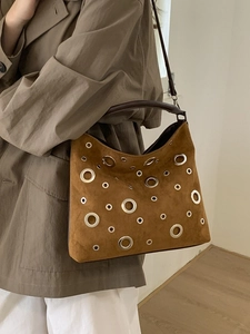 Brown suede tote bag with silver metal eyelets and adjustable shoulder strap for women