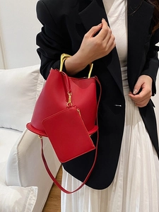 Red bucket bag with gold U-shaped handles and a small zipper pouch for versatile styling