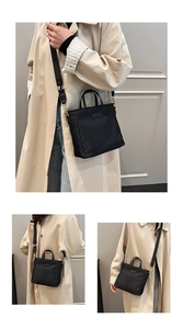 Detail of waterproof black nylon handbag with gold hardware and removable shoulder strap