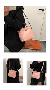 Pink nylon crossbody bag detail showing top handles and adjustable strap for daily use