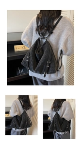 Detail of vintage black leather backpack showing matte texture and silver D-ring hardware
