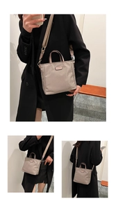 Detail of khaki nylon tote bag featuring adjustable wide strap and metallic brand logo