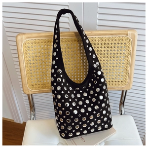Close-up of silver rivet studs on black suede punk style tote bag against white blinds