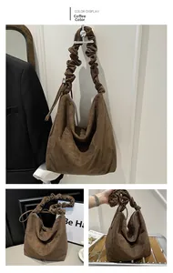 Detail of coffee brown pleated shoulder strap on a soft suede leather crossbody tote