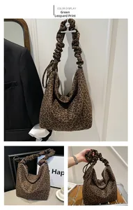 Detail of green leopard print hobo bag with textured ruched strap and spacious interior