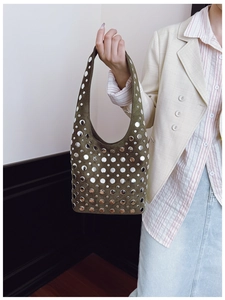 Close-up of dark green suede hobo bag with polished silver rivet studs and sleek strap