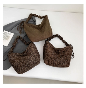 Detail of ruched hobo bags featuring leopard print and brown suede with side drawstrings