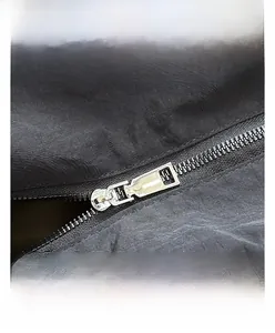 Macro shot of silver metal zipper on quilted nylon fabric of black shoulder bag