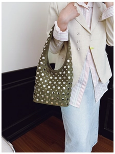 Detail of dark green suede tote bag featuring silver studs and punk style decorations