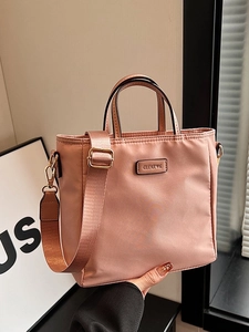 Pink nylon tote bag with wide shoulder strap and gold hardware for women's daily commute