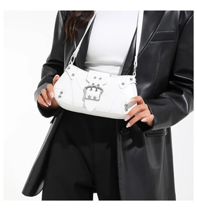 Detail of white PU leather motorcycle bag with silver rivets and metal buckle flap