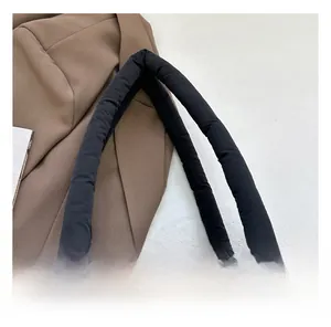 Detail of padded quilted nylon strap on a black oversized shoulder bag for extra comfort