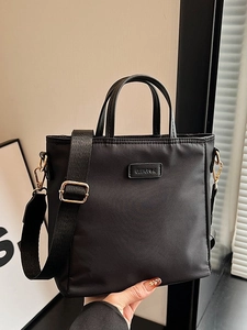 Black nylon tote bag with wide shoulder strap and Clear-K logo shown in handheld use