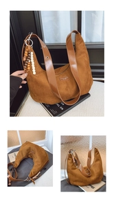 Detail of brown suede hobo bag with wide leather strap and decorative wood bead tassel