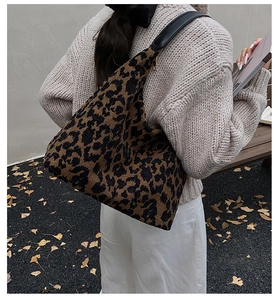 Close-up of leopard print oversized hobo bag with black leather strap and gold zipper