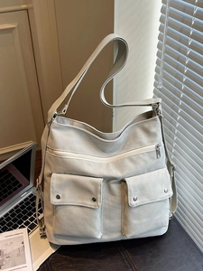 Minimalist off-white canvas tote bag with functional pockets and large capacity for commuting