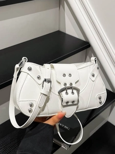 White faux leather baguette bag with silver rivets and metal buckle on adjustable strap