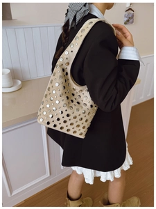 Detail view of beige suede hobo bag with punk-style silver metal rivet studs