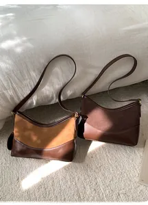 Detail minimalistischer Leder-Halbmond-Schultertaschen in Braun- und Kaffeetönen