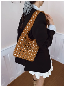 Brown suede shoulder bag with silver studs worn by a model in punk aesthetic