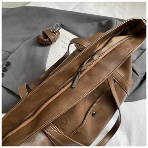 Vue détaillée du sac cabas vintage en cuir marron avec fermeture éclair et bandoulière