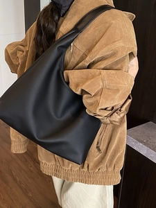 Minimalistische schwarze Leder-Einkaufstasche von einem Model für den Alltag getragen