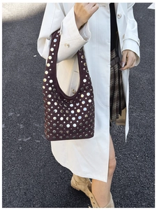 Detail of dark brown suede hobo bag with silver metallic studs in a street style shot