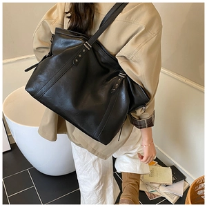 Grand sac cabas noir vintage avec rivets en étoile porté par un mannequin en intérieur