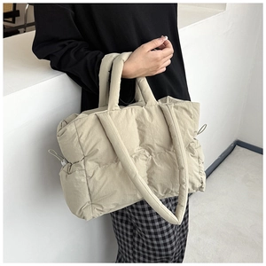 Detail of off-white quilted nylon shoulder bag featuring grid stitching and drawstring
