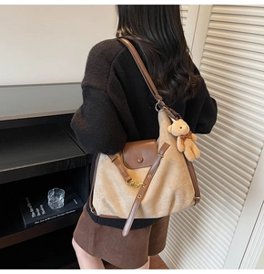 Details der Vintage-Schultertasche aus Canvas mit braunem Leder und Plüschbär-Anhänger
