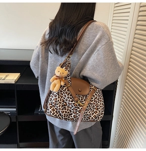 Detail der Schultertasche mit Leopardenmuster, Lederklappe und Bären-Anhänger
