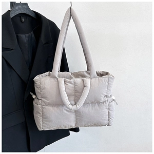 Detailed view of quilted nylon tote bag with drawstring side pockets and dual handles