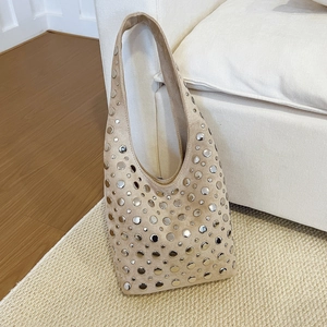 Beige suede hobo bag with silver rivets on a shoulder tote in punk aesthetic