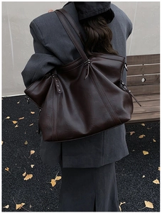 Détail du sac cabas en similicuir marron foncé avec surpiqûres et boucles argentées