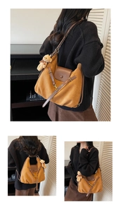 Nahaufnahme der karamellfarbenen Wildleder-Tasche mit Lederschnalle und Bärenanhänger