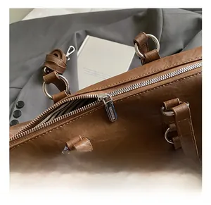 Close-up of brown leather tote bag with silver hardware and striped fabric lining