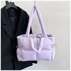 Detail of purple quilted nylon puffer tote bag with dual straps and side drawstrings
