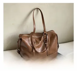 Detail view of the silver metal ring connectors and soft brown leather on a tote bag