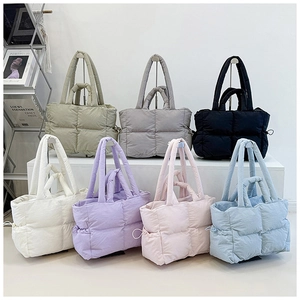 Detail of multi-color quilted nylon tote bags with padded texture and double handles
