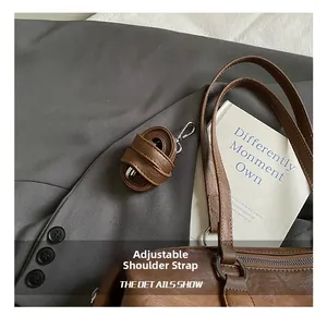 Detail of adjustable dark brown leather strap with silver buckle on a vintage tote bag