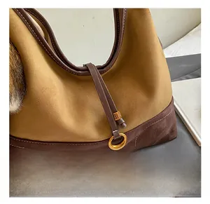 Detail of vintage suede tote bag showing gold hardware and contrast color stitching
