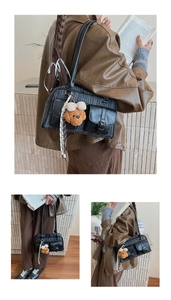 Close-up of vintage plaid Boston bag with leather trim and a cute plush dog pendant
