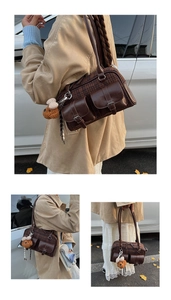 Detail of vintage plaid Boston bag with brown leather accents and plush dog charm