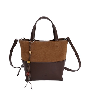 Two-tone leather bucket bag with top handle, detachable strap and tassel charm